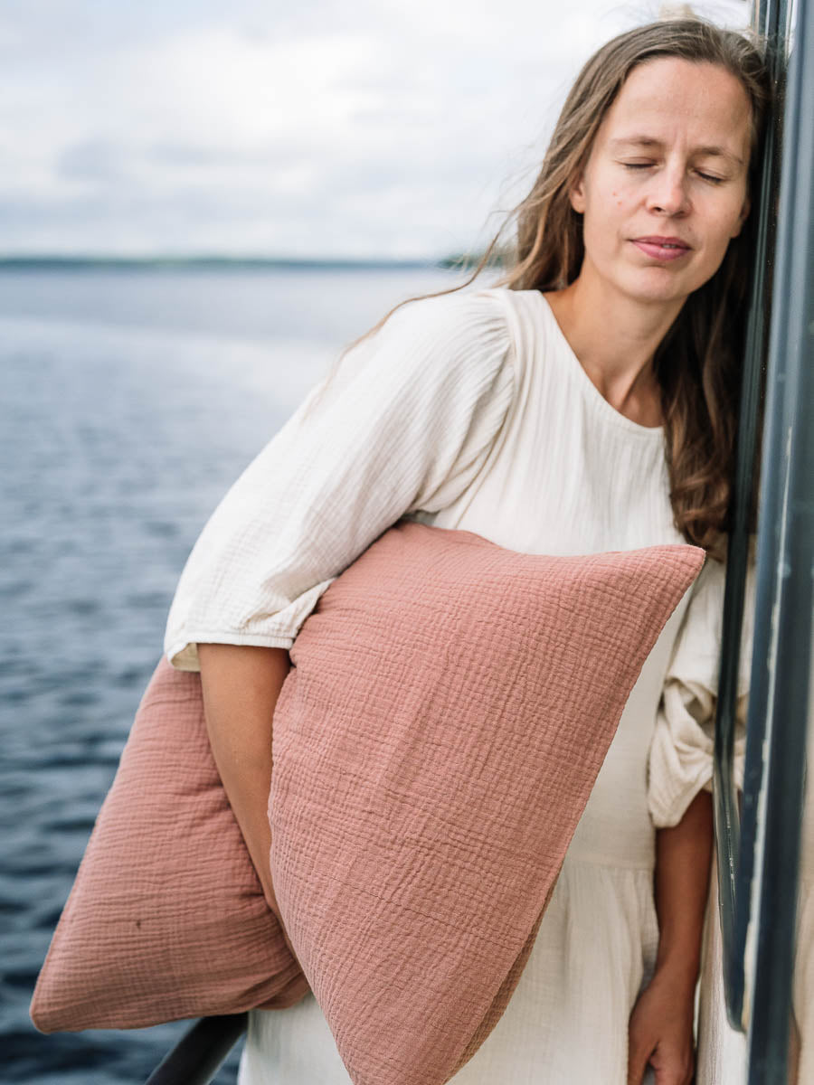 Kvinna håller ett örngott för vuxna i Old blush