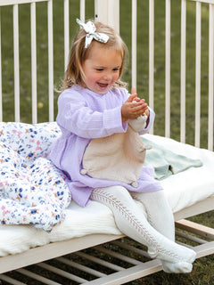 asukuva_harsomekko_pitkahihainen_sukkahousutsivupitsilla_rusettipanta_pinnasangynpaallinen_vauvanpussilakanat_uninalle_2 [mekko lavender, sukkahousut cream]