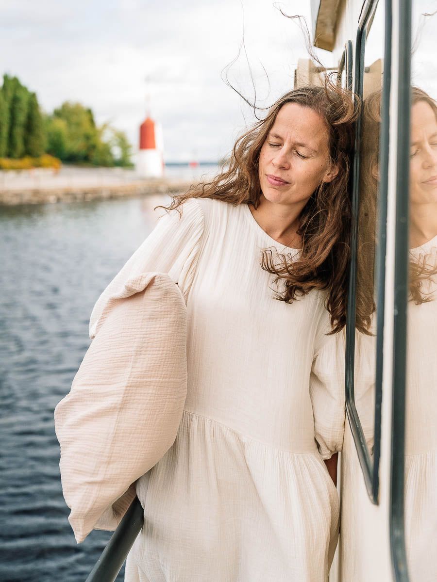 Kvinna på en båt som håller ett örngott för vuxna i färgen Light beige