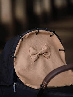 Light brown waffle stroller curtain with a bow attached to a pram